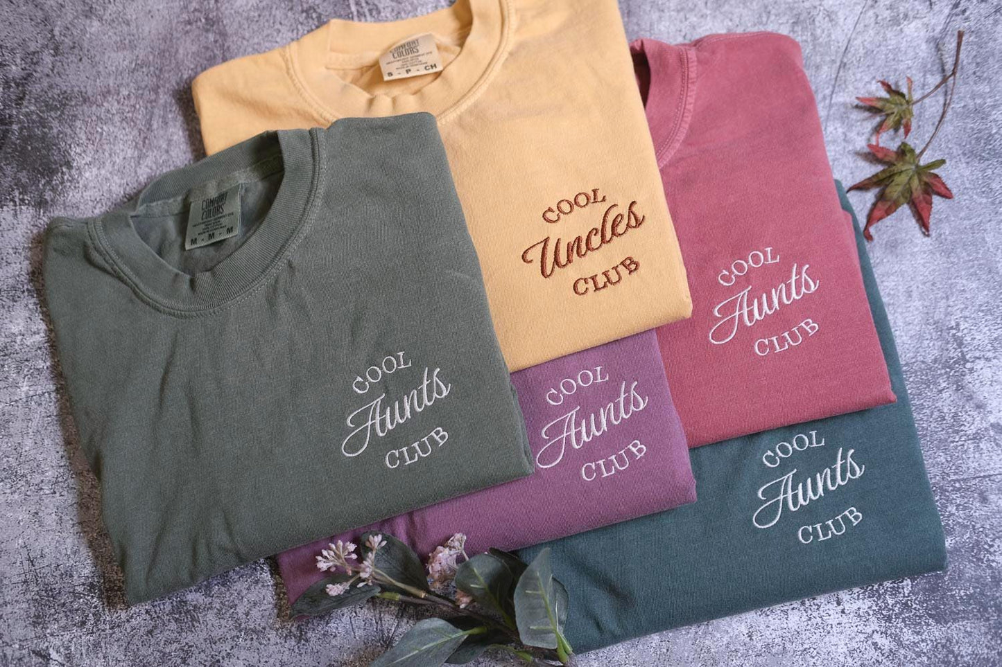 a group of four t - shirts sitting on top of a table