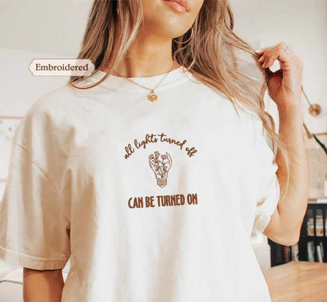 A woman wearing a white t-shirt with a printed message on it.