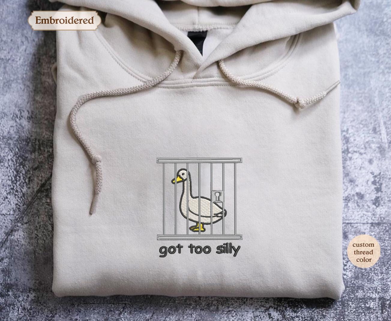 a hooded sweatshirt with a duck in a cage