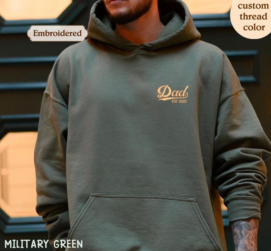 a man wearing a military green hoodie with the words dad printed on it