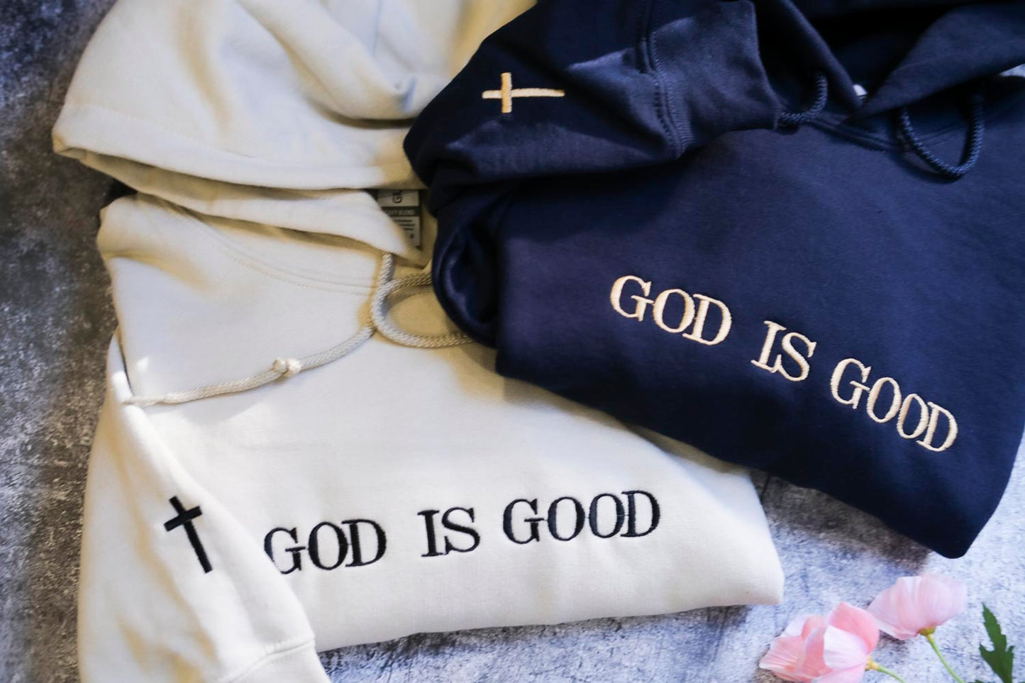 two hooded sweatshirts with the text "GOD IS GOOD" printed on them.