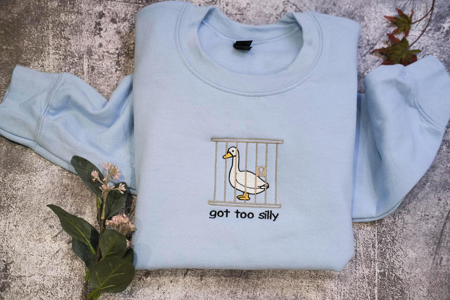 a blue shirt with a duck in a cage on it