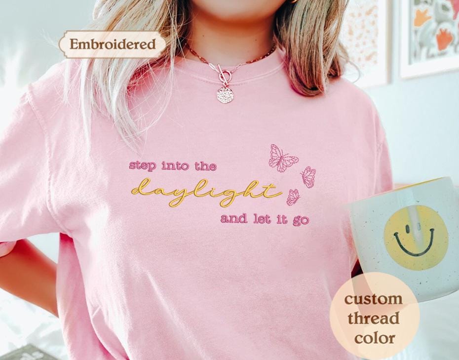 a woman wearing a pink shirt and holding a coffee cup