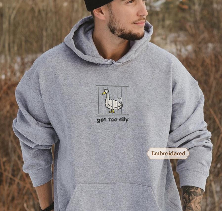 a man wearing a grey hoodie with a duck on it