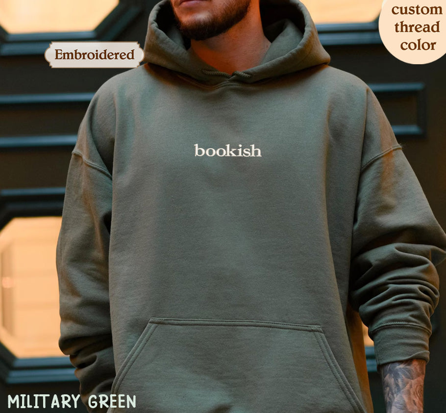 A person wearing a green hoodie with the word "bookish" printed on it.