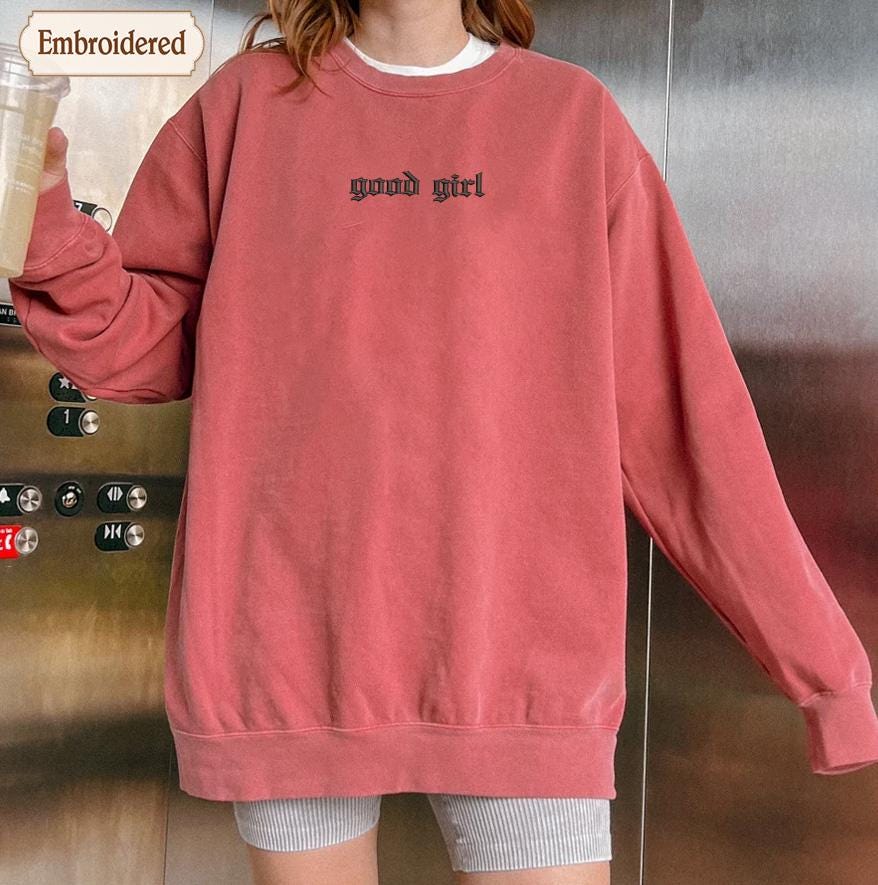 a woman standing in front of a refrigerator holding a drink