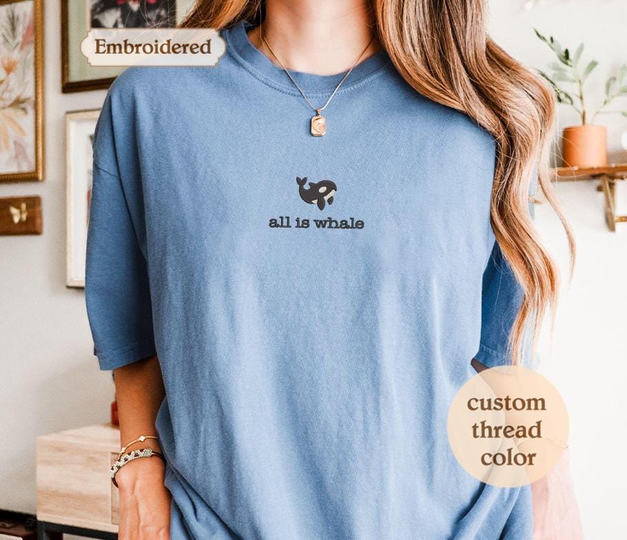 a woman wearing a blue shirt with a black dog on it