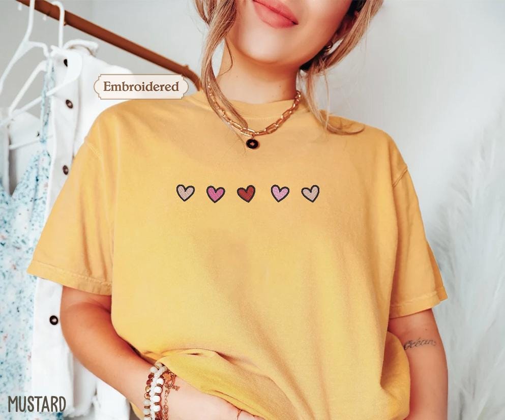 a woman wearing a yellow shirt with hearts on it