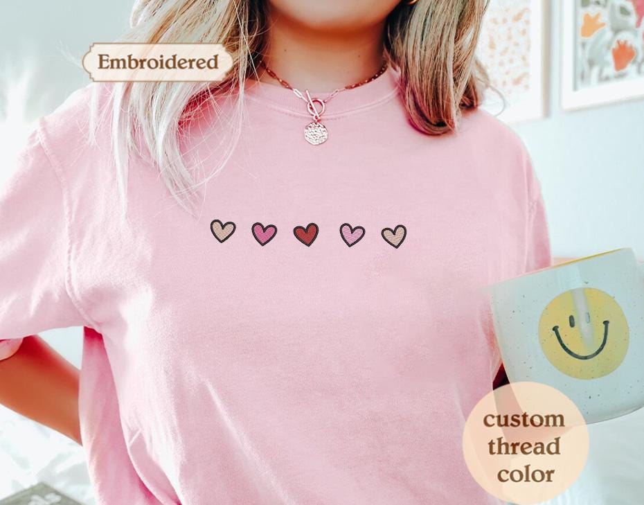 a woman wearing a pink shirt with hearts on it