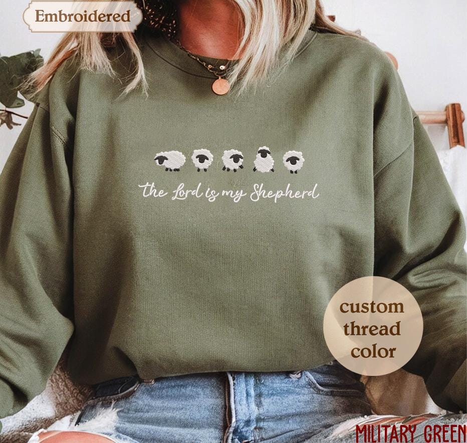 a woman wearing a green sweatshirt with sheep on it