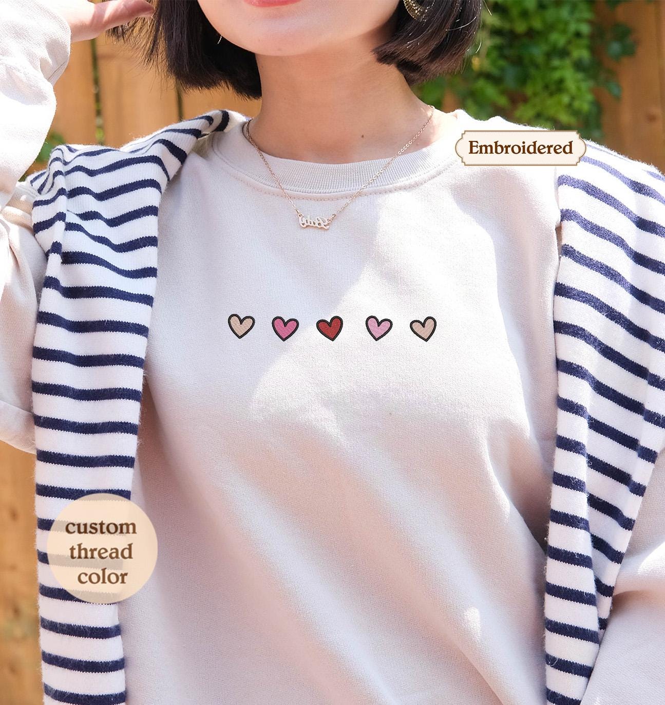 a woman wearing a white shirt with hearts on it