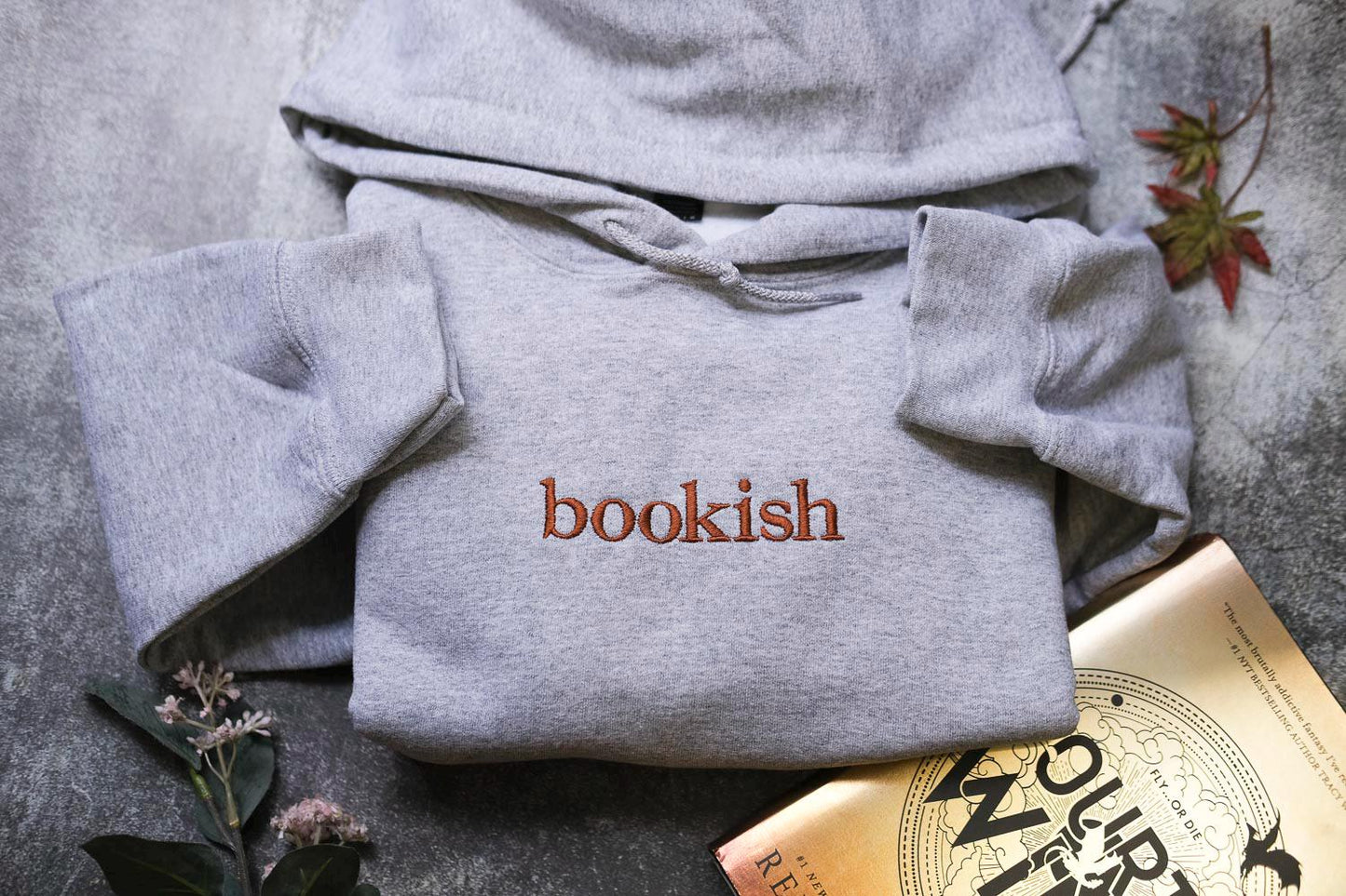 a bookish sweatshirt and a book on a table