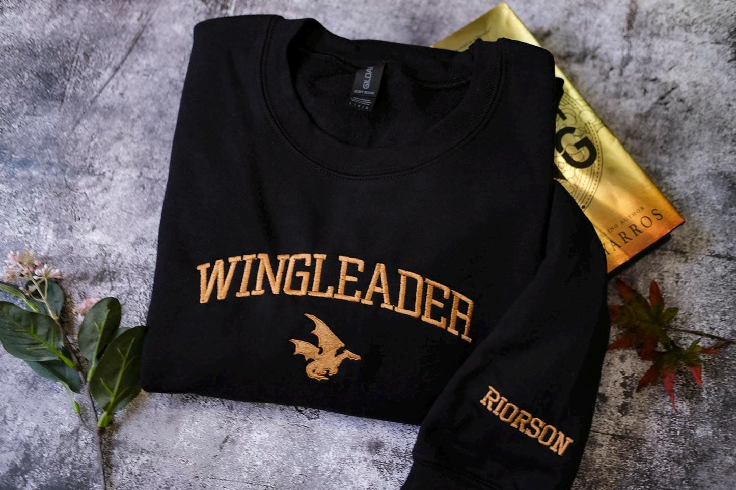a black sweatshirt with a gold wingleader on it