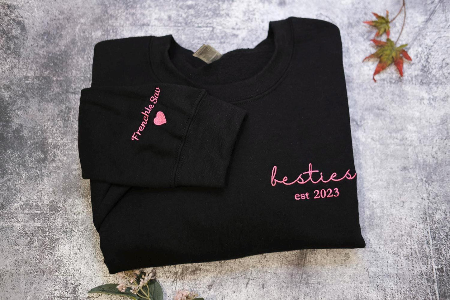 a black t - shirt with a pink heart on it