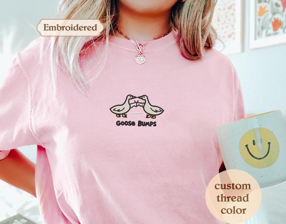 a woman wearing a pink shirt with two birds on it