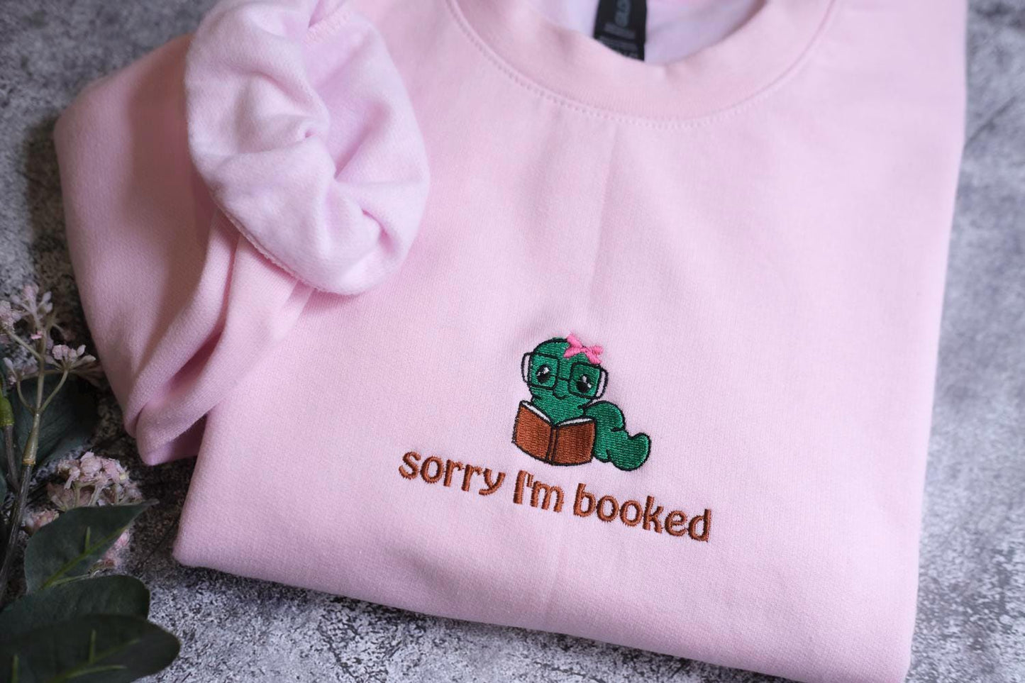 a pink shirt with a green turtle embroidered on it