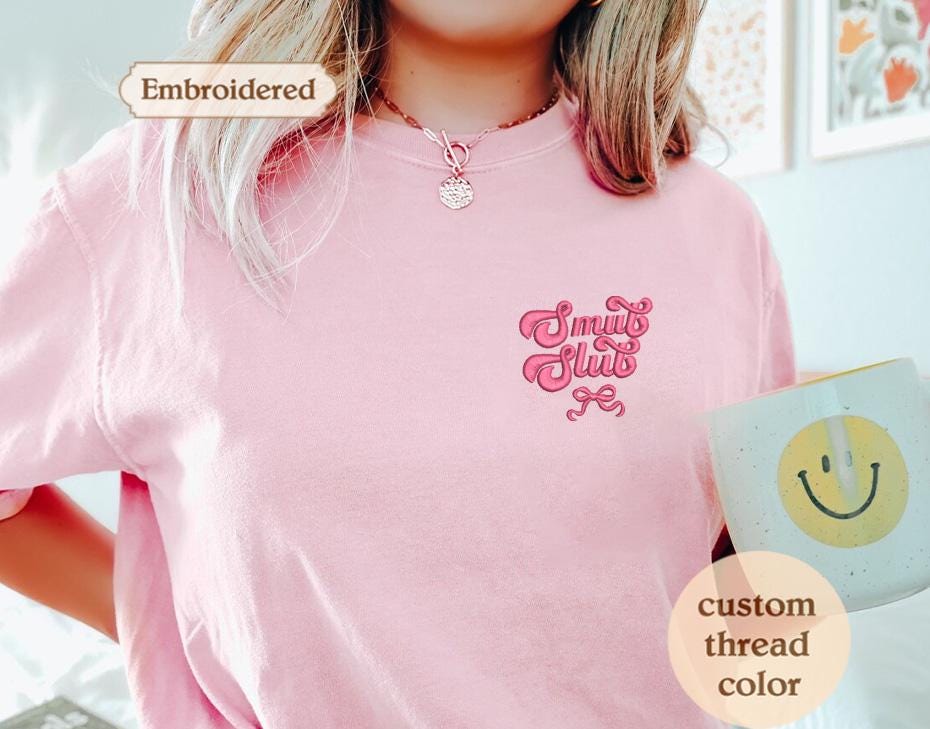 a woman wearing a pink tshirt holding a cup of coffee