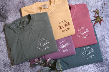 a group of four t - shirts sitting on top of a table