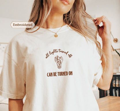 A woman wearing a white t-shirt with a printed message on it.