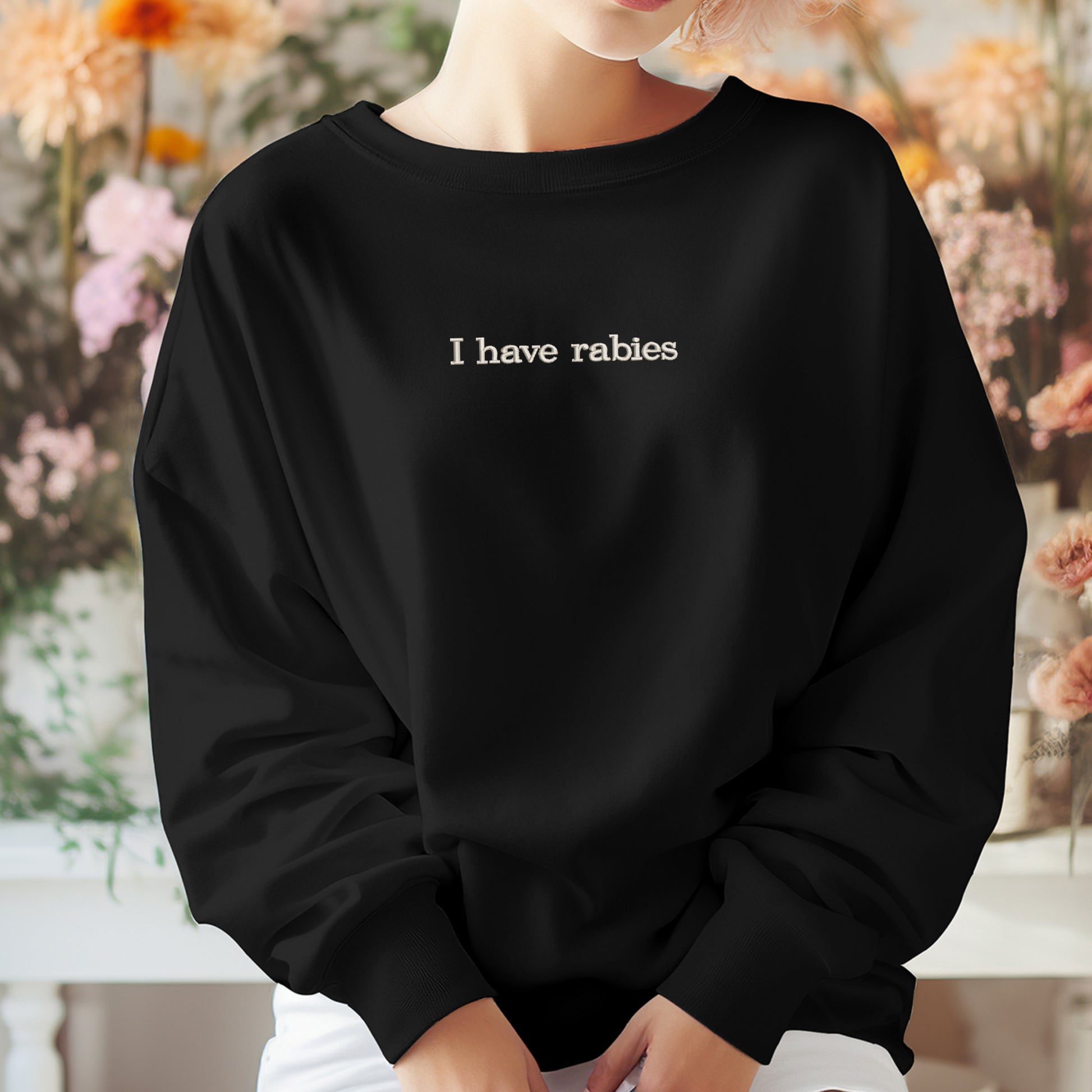 A person wearing a black sweatshirt with the text "I have Rabies" printed on it.