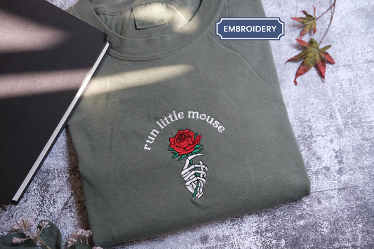 a gray t-shirt with a red rose graphic and the text "run little mouse" printed on it, along with a skeleton hand holding the rose.