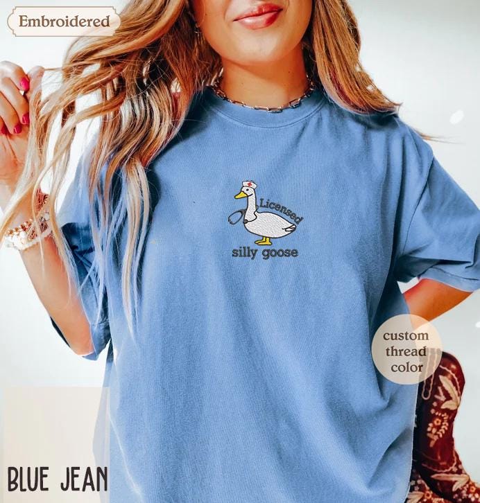 a woman wearing a blue shirt with a duck on it