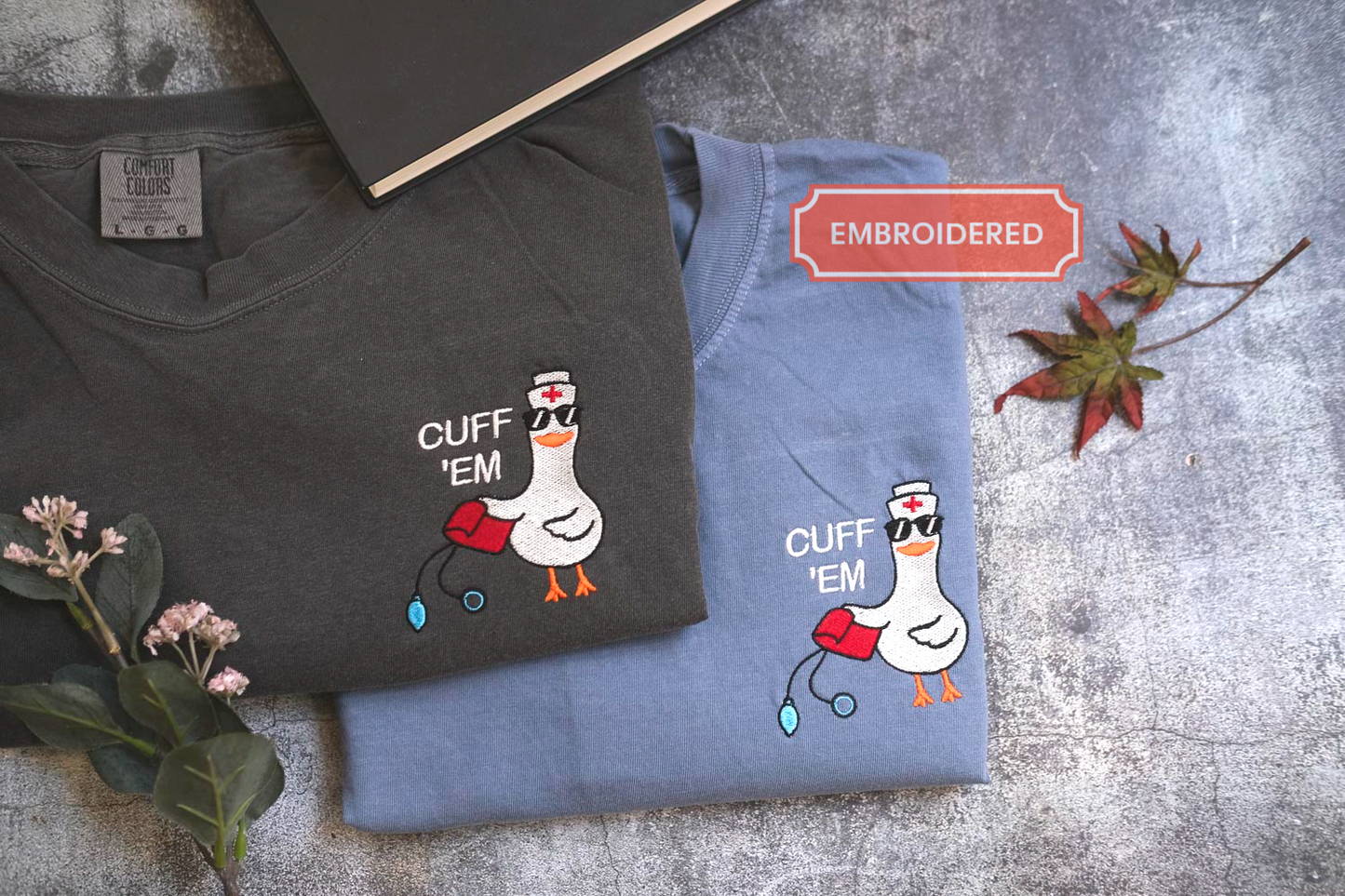 two t-shirts with a cartoon duck wearing a nurse's hat and sunglasses, along with the text "CUFF 'EM" printed on them.