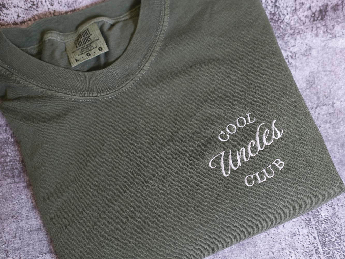 A gray t-shirt with the text "Cool Uncle Club" printed on it.