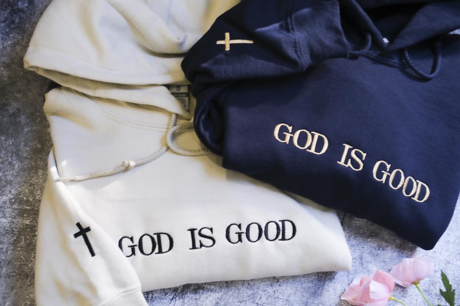 two hooded sweatshirts with the text "GOD IS GOOD" printed on them.