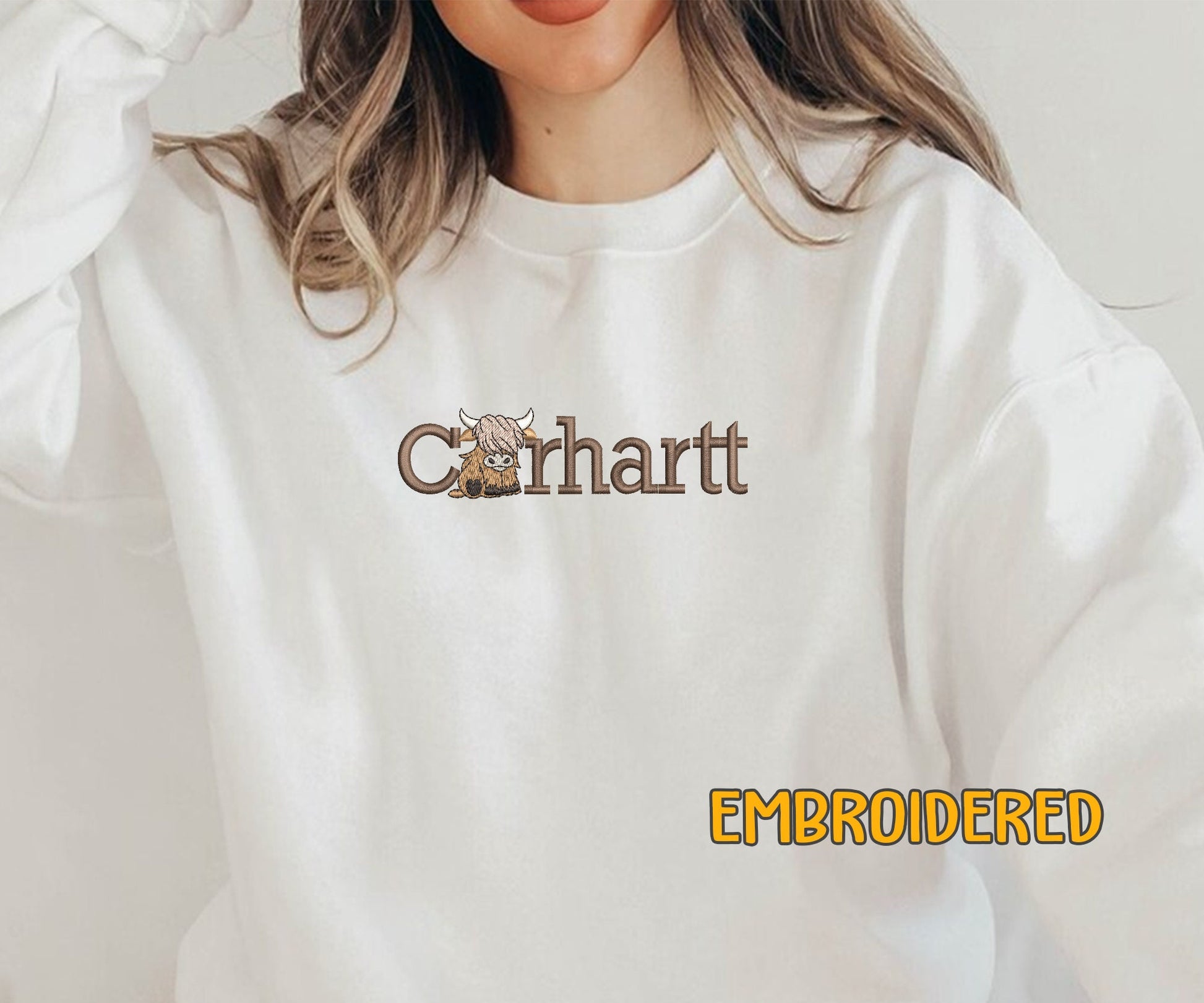 a woman wearing a white sweatshirt with a logo on it
