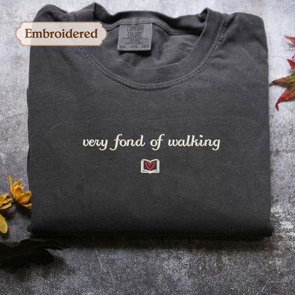 A gray t-shirt with the text "very fond of walking" embroidered on it, along with a small red heart symbol.
