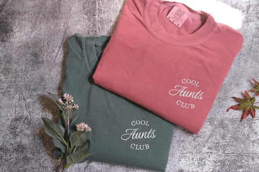 a couple of t shirts sitting on top of a table