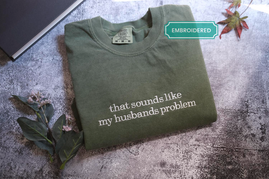 a green t-shirt with white text that says "that sounds like my husband's problem".
