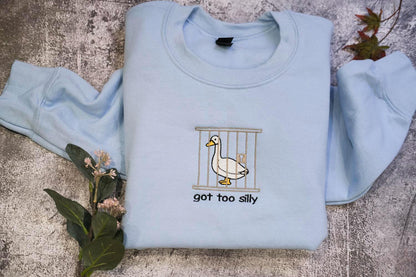a blue shirt with a duck in a cage on it