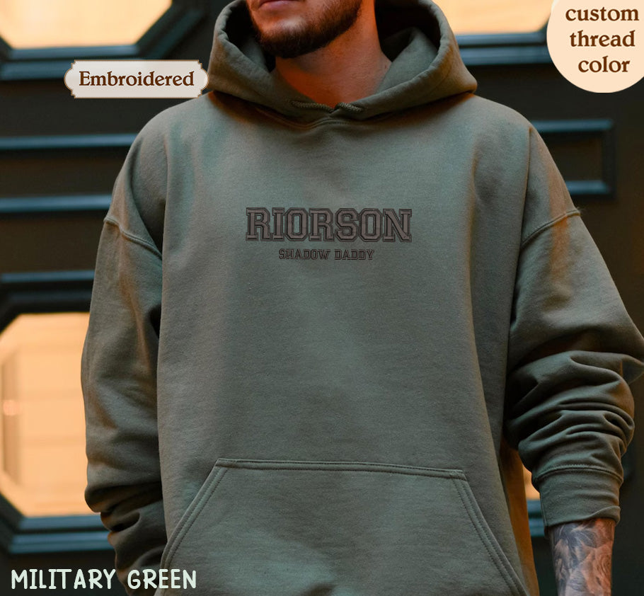 A person wearing a green hoodie with the text "RIORSON SHADOW DADDY" printed on it.