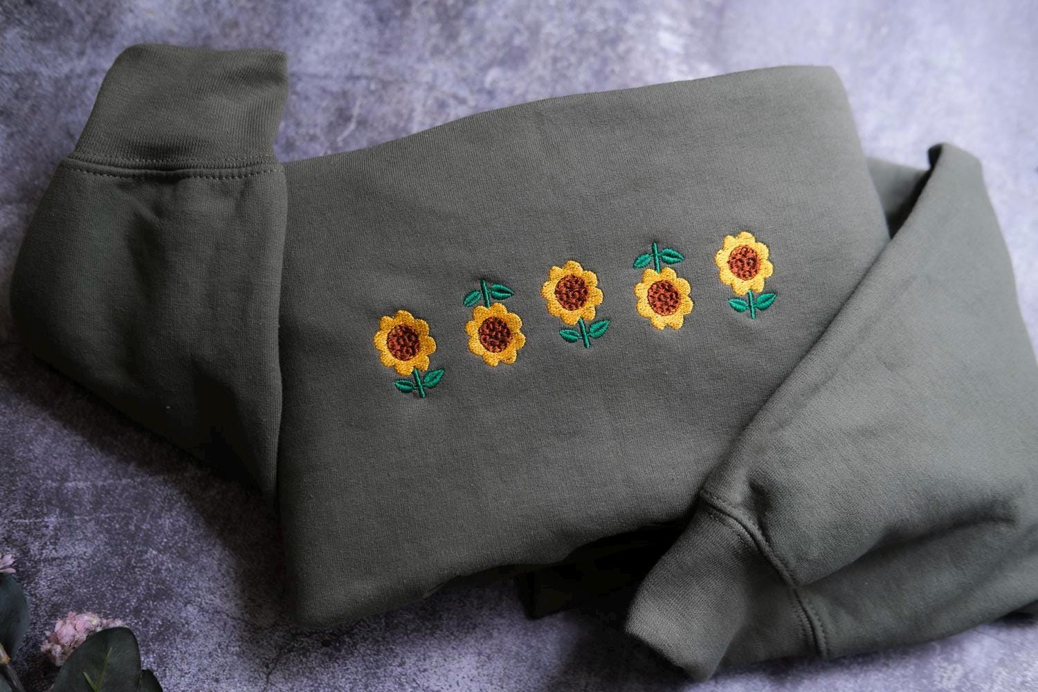 a gray sweatshirt with embroidered sunflowers on it