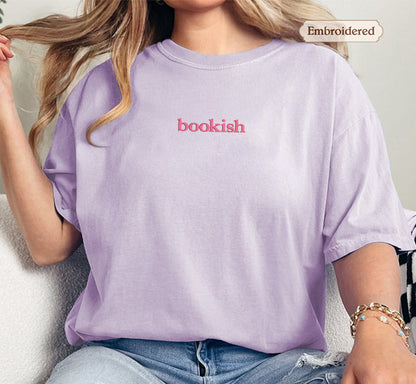 A person wearing a purple t-shirt with the word "bookish" printed on it.