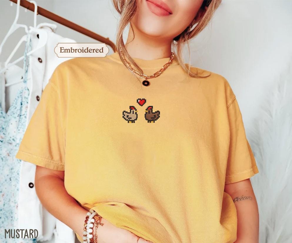 a woman wearing a yellow shirt with two chickens on it