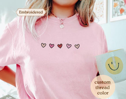 a woman wearing a pink shirt with hearts on it