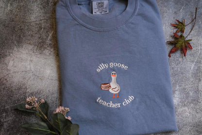 a blue t - shirt with a duck embroidered on it
