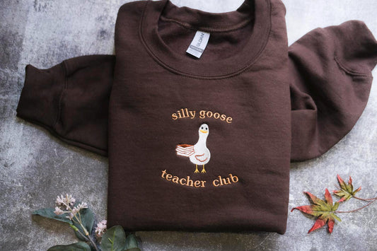 a brown shirt with a goose on it