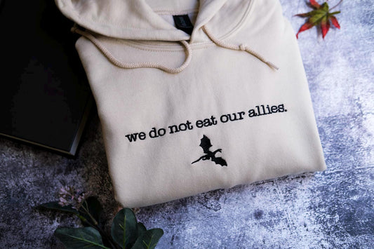 a white sweatshirt with the words we do not eat our alleas on it