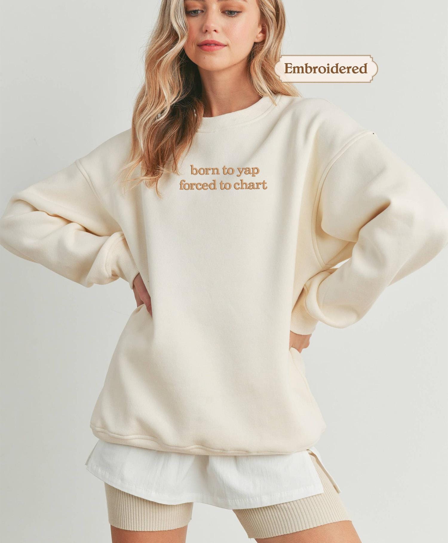 a woman wearing a white sweatshirt and shorts
