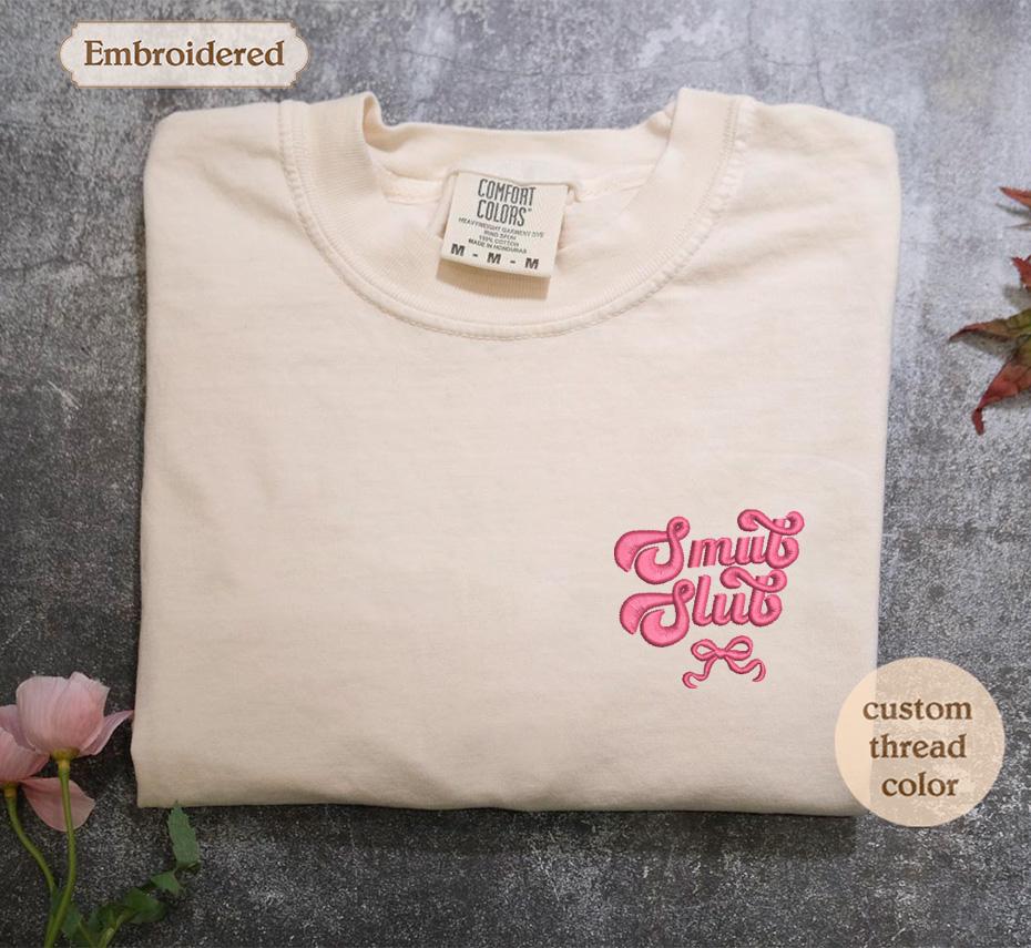 a white t - shirt with a pink design on it