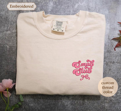 a white t - shirt with a pink design on it