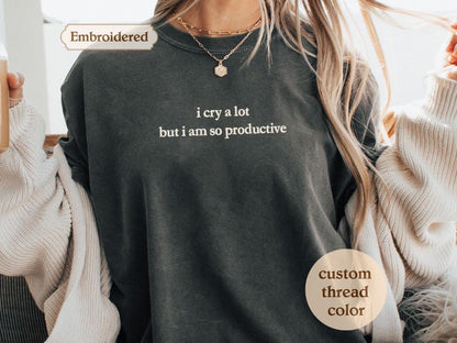 a woman holding a cup of coffee and wearing a long sleeved shirt