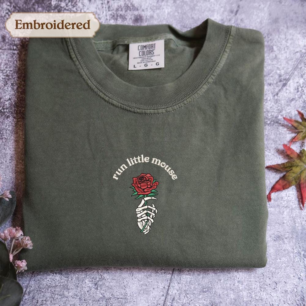 a green t - shirt with a rose embroidered on it