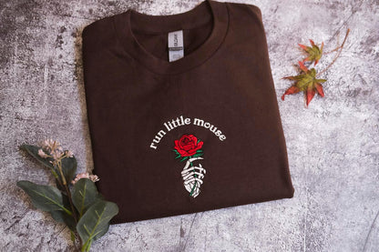 a brown t - shirt with a rose on it