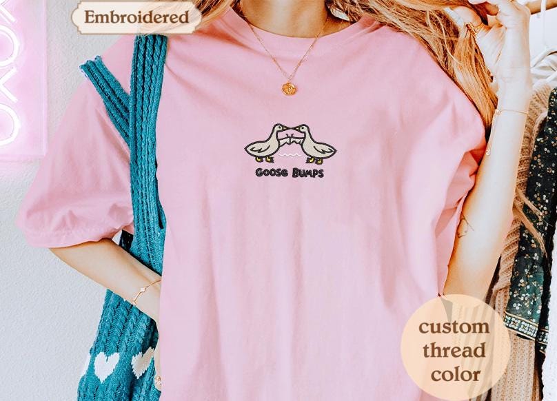 a woman wearing a pink shirt with two birds on it